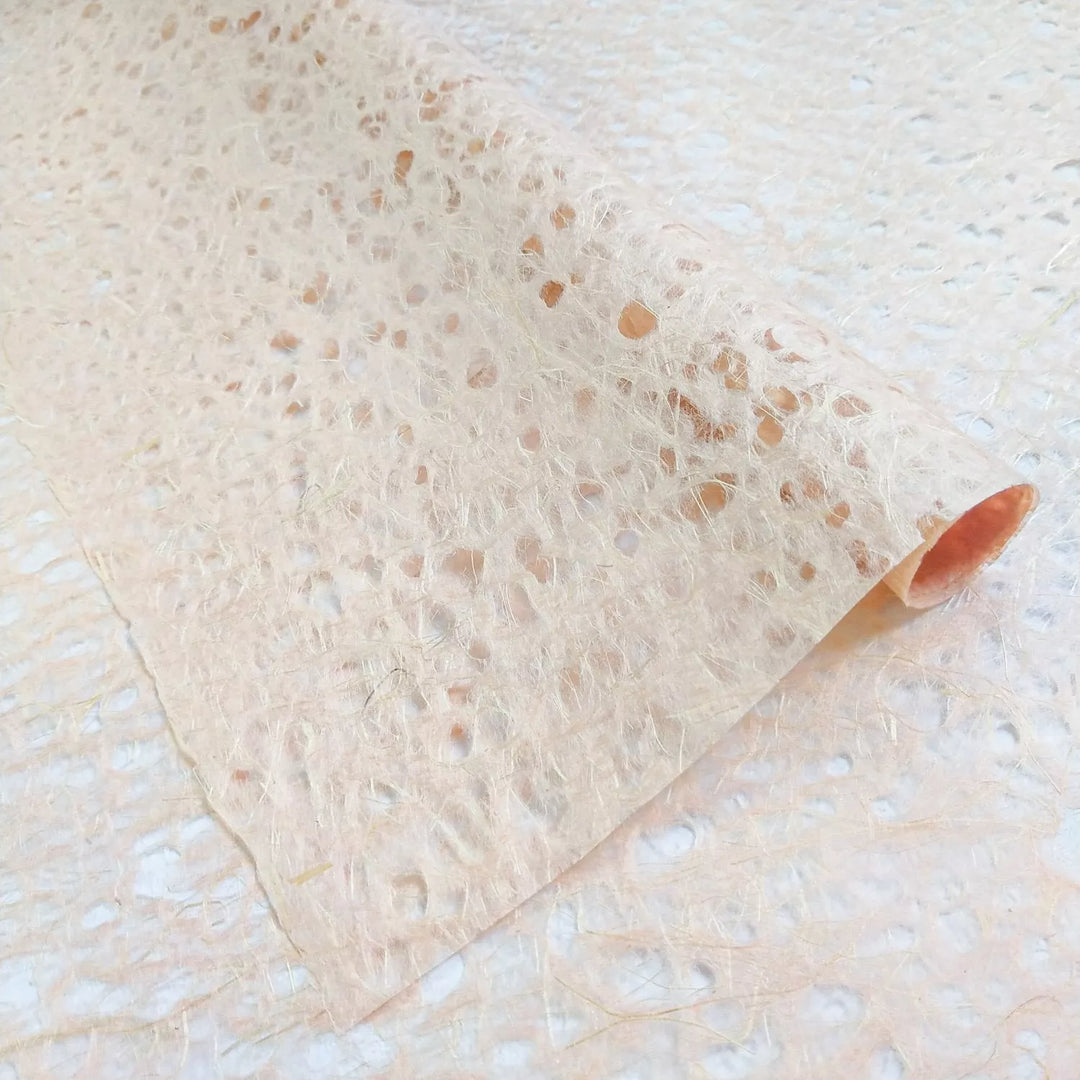 Close-up photo of Kozo Studio mulberry paper, featuring Asarakusui Lace Paper in Old Rose with a semi-translucent finish and handmade fibrous details.