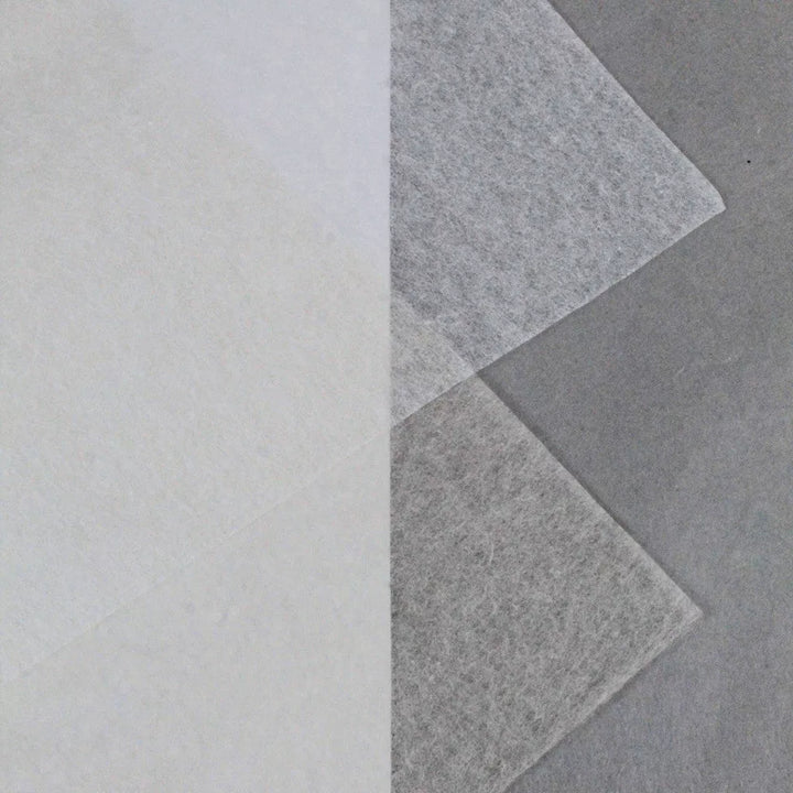 Three overlapping sheets of Kozo Studio’s Conservator No.1 washi paper (8.5 gsm) are displayed on a gray background—one angled, two vertical—highlighting the delicate, layered quality of this 15-sheet pack crafted from kozo pulp.