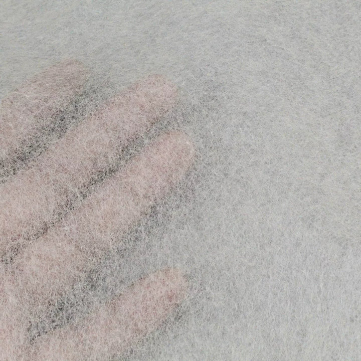 A hand presses against a sheet of Kozo Studio’s Conservator No.1 (8.5 gsm; 15 sheets/pack), its thin, translucent surface revealing both texture and fingers.
