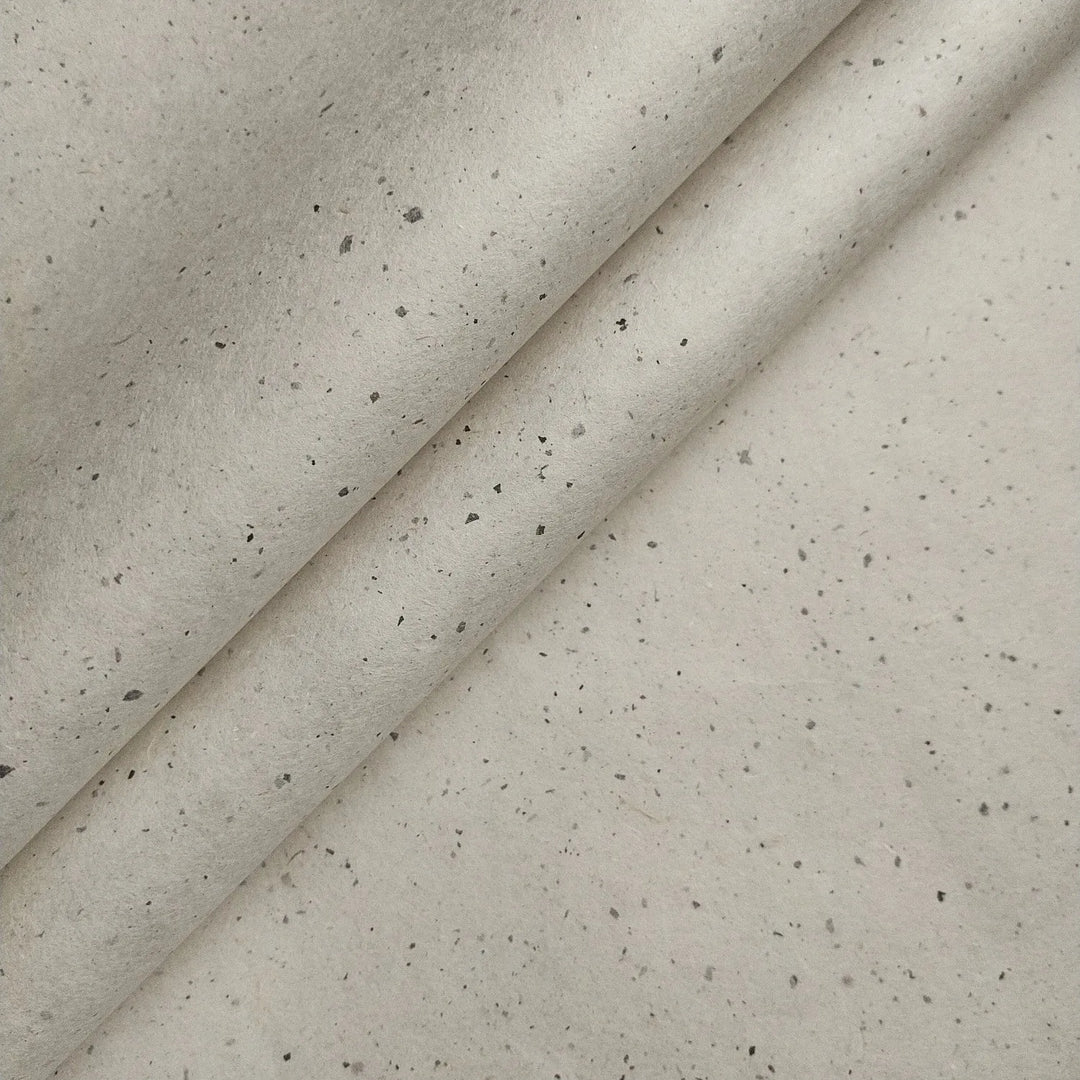 Chiri Kozo Paper Natural from Kozo Studio rests partially folded, revealing the soft texture and organic specks typical of premium handmade mulberry paper.