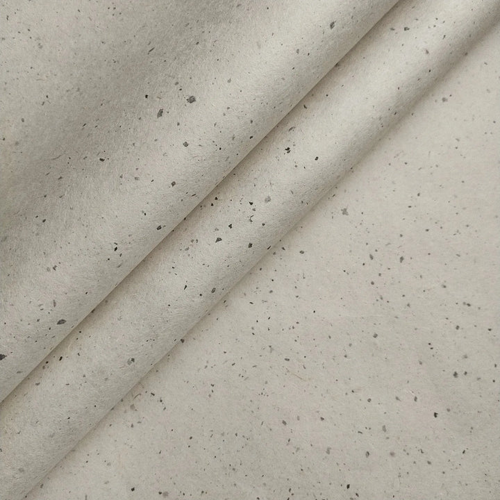 Chiri Kozo Paper Natural from Kozo Studio rests partially folded, revealing the soft texture and organic specks typical of premium handmade mulberry paper.