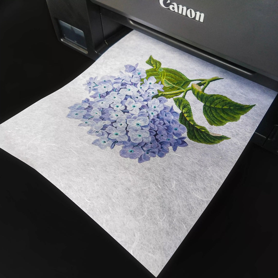 Kozo Studios A4 Decoupage Unryu Mulberry Paper (40 Sheets, 30 gsm) is printing a vibrant, detailed illustration of light purple hydrangeas and green leaves—ideal for decoupage with excellent ink absorption.