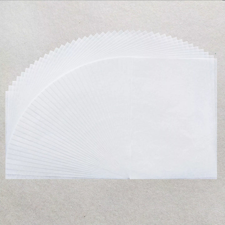 A stack of Kozo Studio’s A4 Decoupage Unryu Mulberry Paper (40 Sheets, 30 gsm) is fanned out in a semi-circle on a textured light gray surface.