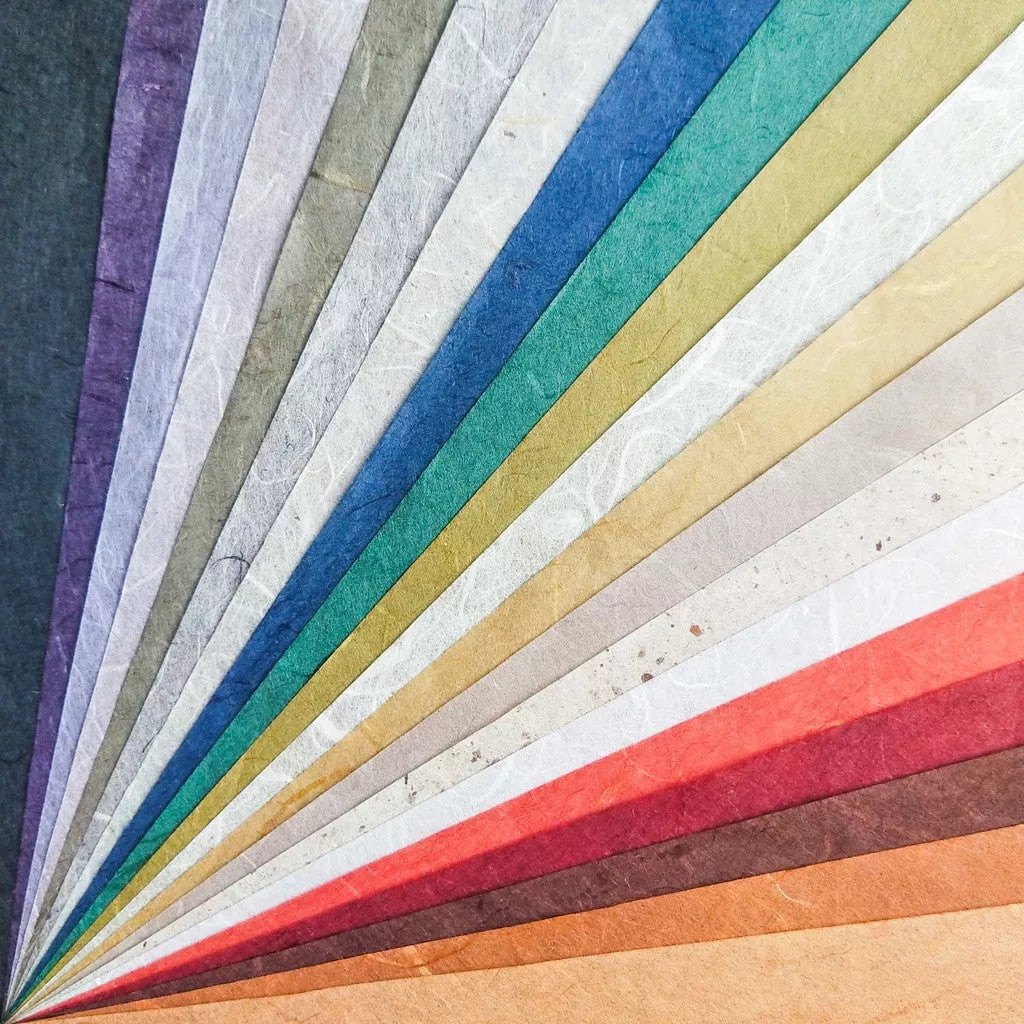 The Assorted A4 Earth Unryu Kozo Paper Set by Kozo Studio features 40 colorful sheets of mulberry paper with radial patterns. Enjoy purple, grey, blue, green, yellow, beige, red, and brown hues—all with subtle textures.