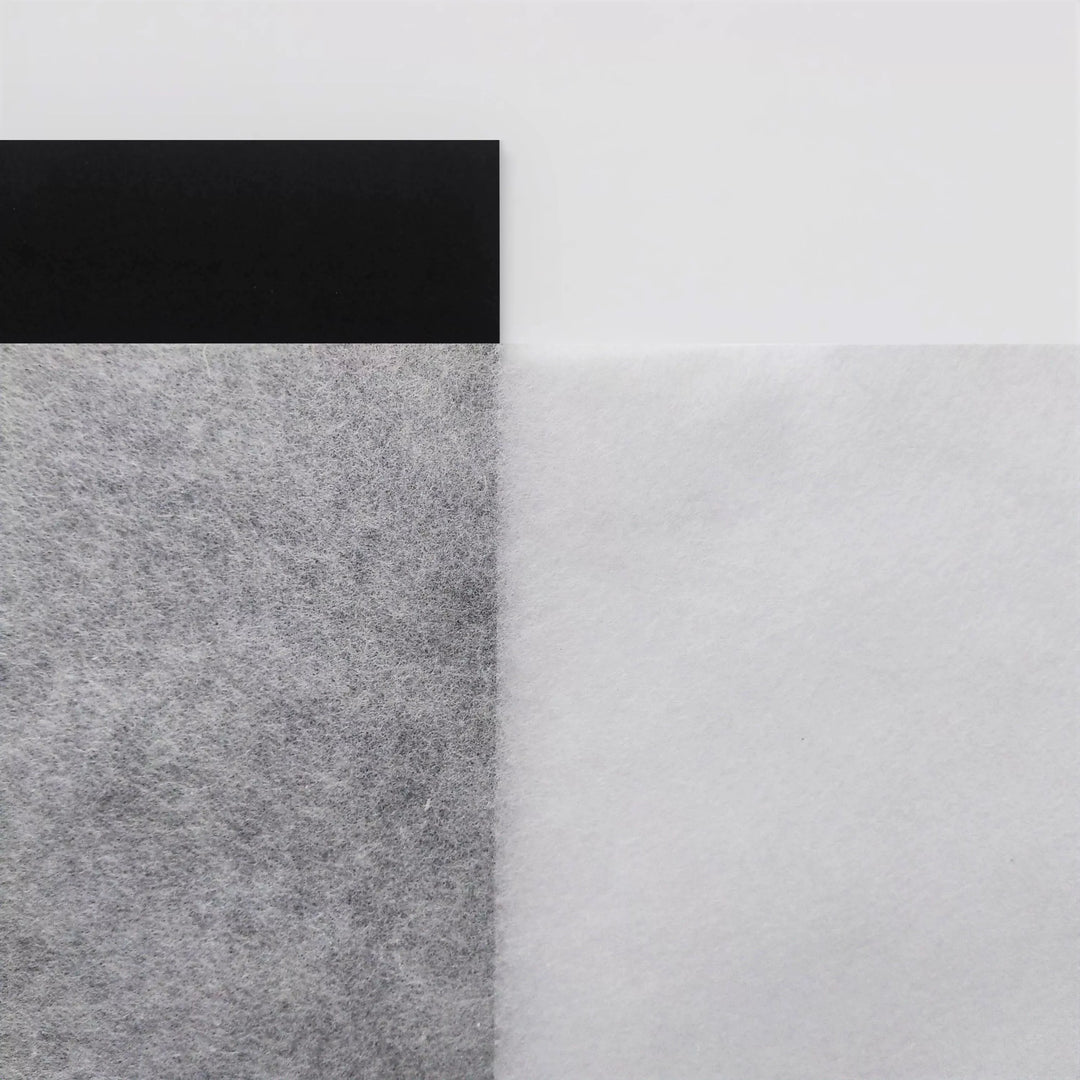 In the upper left, a textured black rectangle contrasts with a fuzzy grey area similar to mulberry paper. Next to it is a sheet from Kozo Studios A4 Extra Thin White Kozo Paper, forming a minimalist composition with distinct geometric and textural elements.