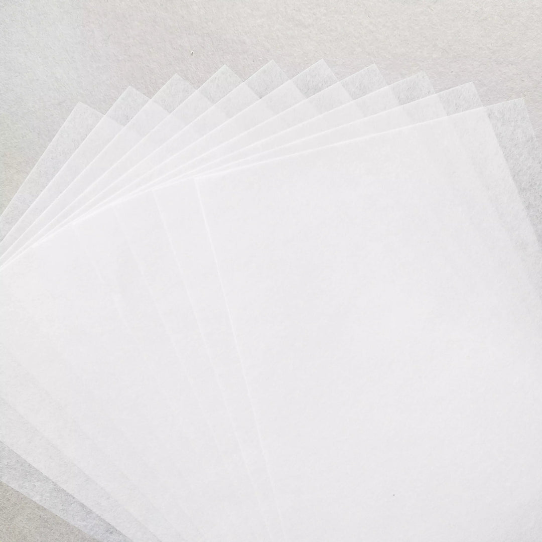 A fan arrangement of Kozo Studio’s A4 Decoupage Plain Mulberry Paper (40 Sheets, 30 gsm), translucent white and known for ink absorption, is displayed on a similarly textured white surface.