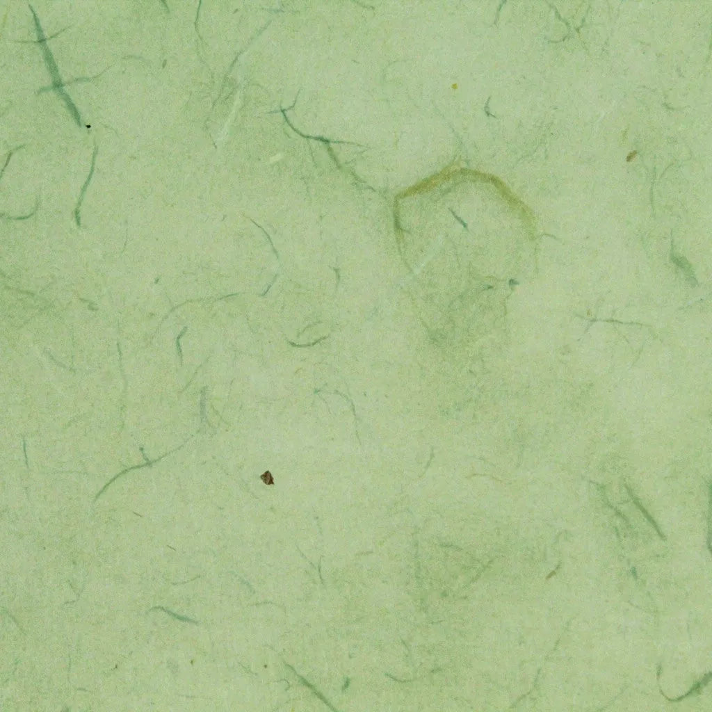 Close-up of mint Water-resistant Kozo Paper by Kozo Studio showcases a texture with thin fibers and subtle color variations. Dark specks add a natural, organic look to the surface.