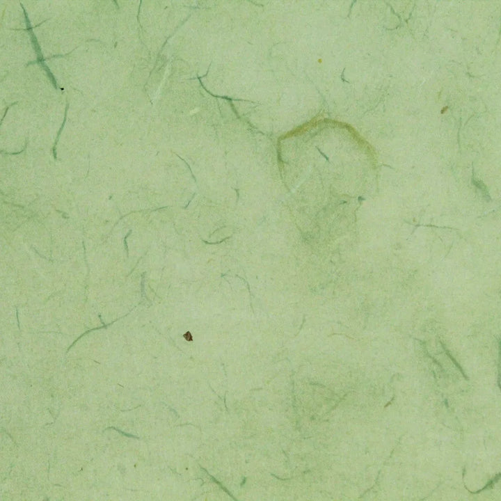 Close-up of mint Water-resistant Kozo Paper by Kozo Studio showcases a texture with thin fibers and subtle color variations. Dark specks add a natural, organic look to the surface.