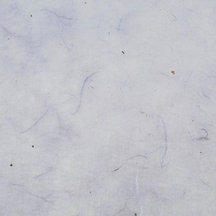 A close-up reveals a textured surface of Water-resistant Kozo Paper (Lavender) by Kozo Studio, with faint lines and small specks, reminiscent of fibers or hair on a light, neutral background, akin to the delicate weave of mulberry paper.