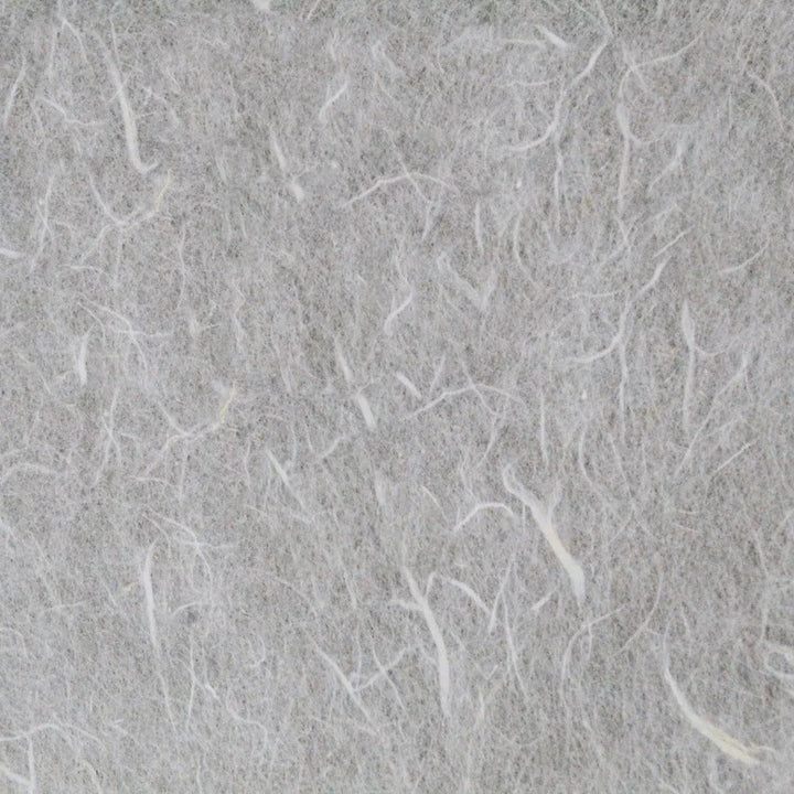 The image highlights a coarse texture reminiscent of felt or wool, with thin white fibers intricately woven. It evokes the delicate weave of mulberry paper, akin to Kozo Studios Water-resistant Kozo Paper (White), creating a soft and fibrous appearance.