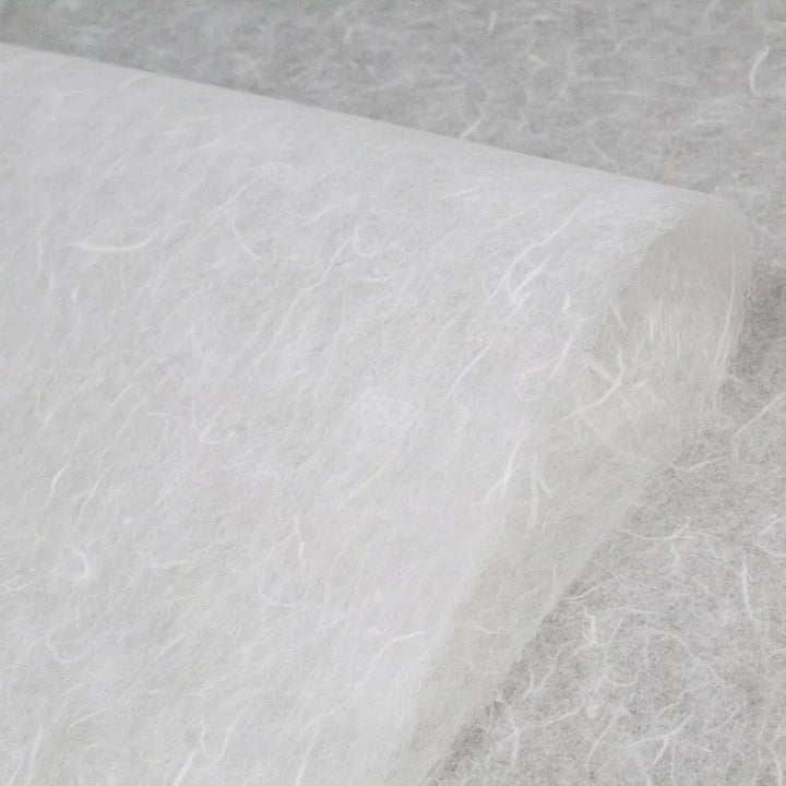 A close-up of Water-resistant Kozo Paper (White) by Kozo Studio shows its fibrous texture similar to mulberry paper. The lightweight, slightly translucent non-woven fabric suits various uses like filtration or crafting.