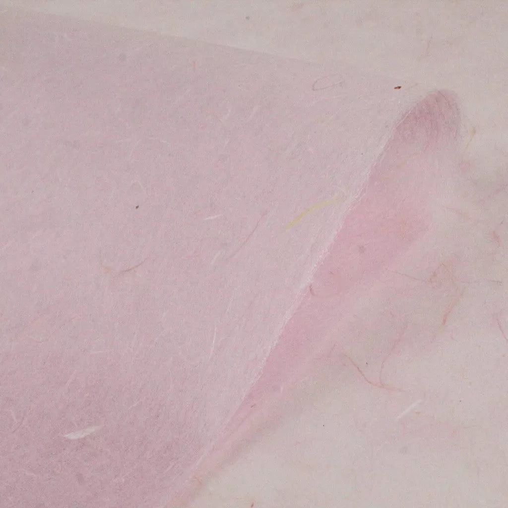 Close-up of Kozo Studios Water-resistant Kozo Paper in pink, featuring a textured, fibrous surface of a delicate mulberry paper with a gently curved edge.
