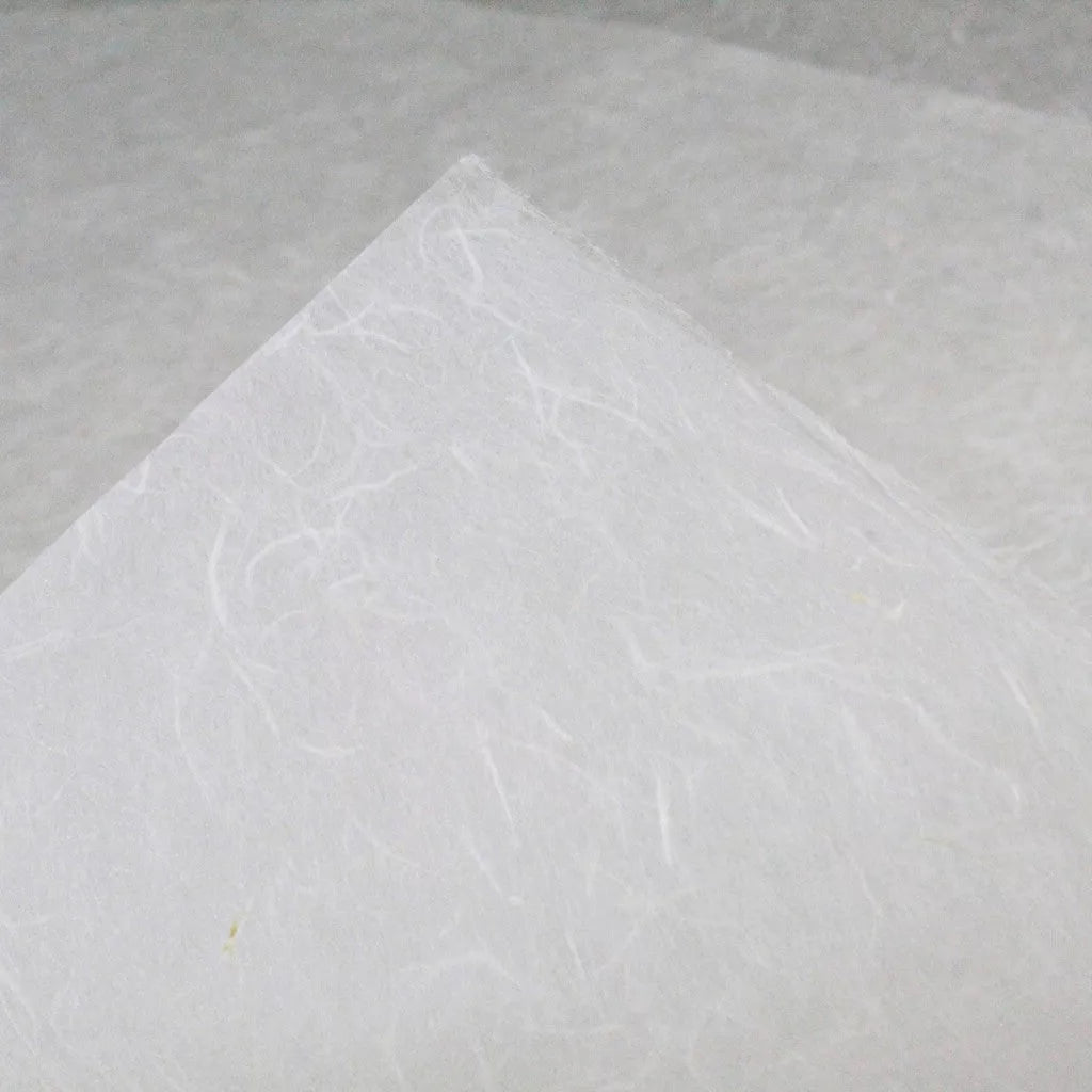 Close-up of Kozo Studios water-resistant Kozo paper (white), showcasing visible mulberry fibers that form a pattern of fine lines and subtle shade variations. It appears slightly translucent, capturing a minimalistic and delicate appearance.