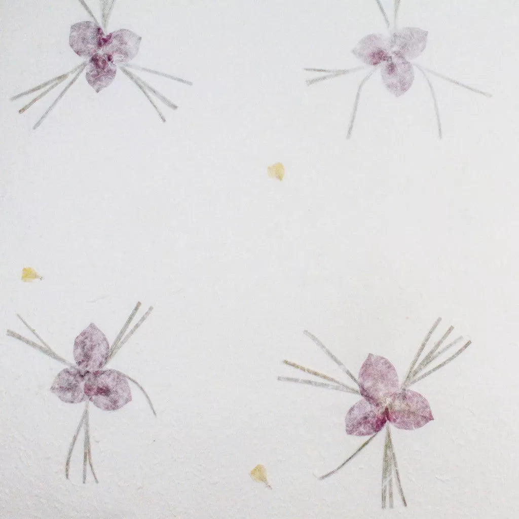 Artisanal handmade paper from Kozo Studio with a textured finish and elegant purple flower accents on mulberry paper.