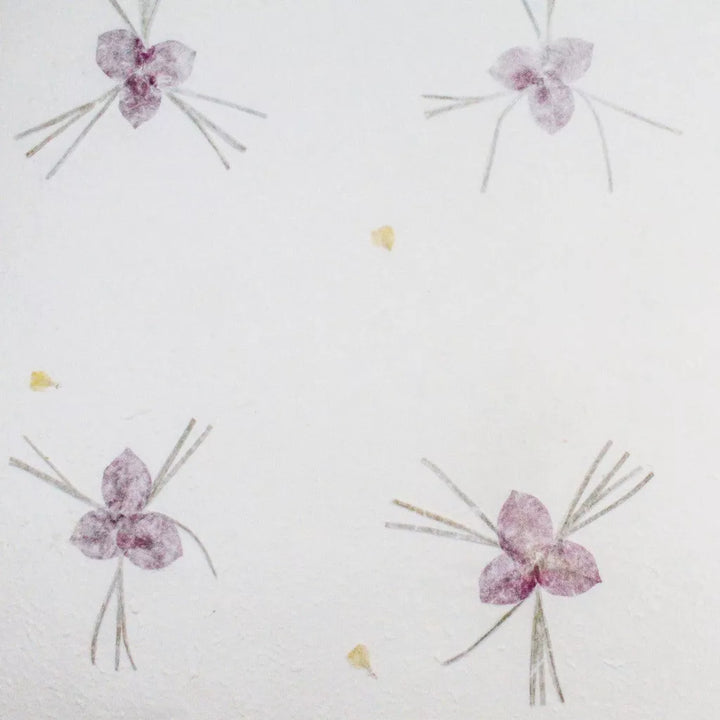 Artisanal handmade paper from Kozo Studio with a textured finish and elegant purple flower accents on mulberry paper.