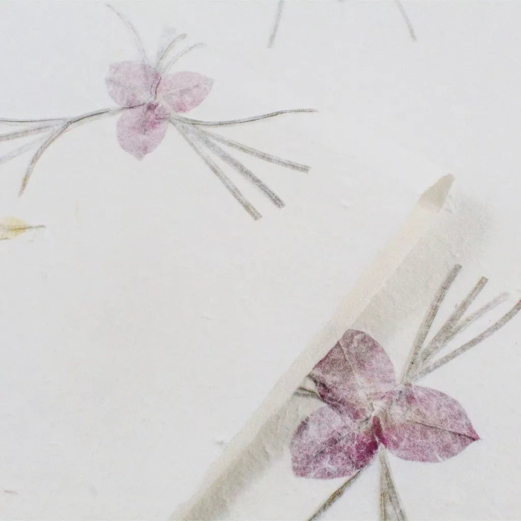 Close-up of handmade mulberry paper by Kozo Studio, showcasing delicate floral patterns and natural curled edges.
