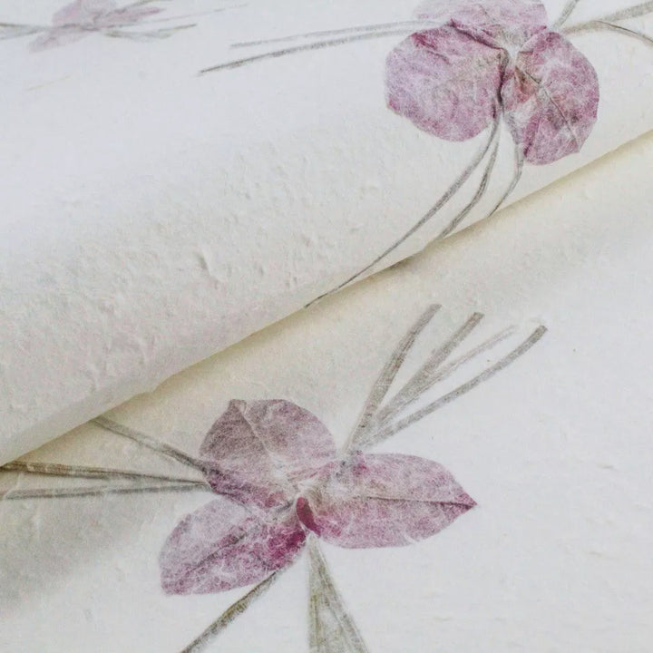 Decorative mulberry paper from Kozo Studio with fine purple flowers and stems embedded in textured handmade paper.