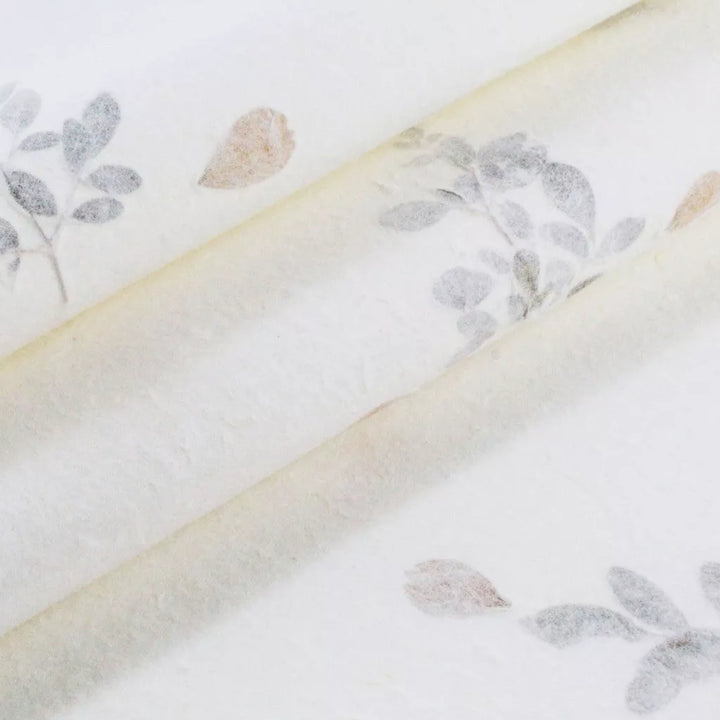 Handmade mulberry paper from Kozo Studio with delicate floral inclusions, ideal for invitations, cards, and other elegant paper crafts.