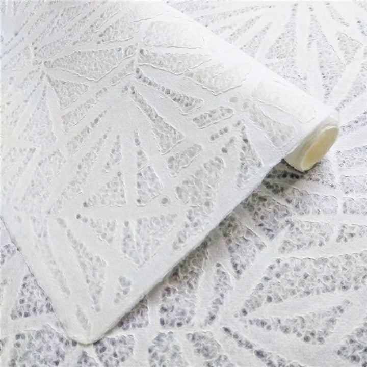 A close-up of Handmade Lace Kozo Paper (Bamboo) by Kozo Studio shows a white textured of mulberry paper, featuring an intricate bamboo pattern. The material is folded and layered to highlight its texture.
