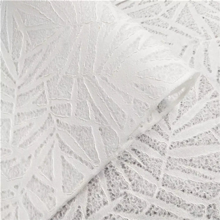 Close-up of Handmade Lace Kozo Paper (Bamboo) by Kozo Studio, showcasing white lace with an overlapping bamboo leaf pattern.