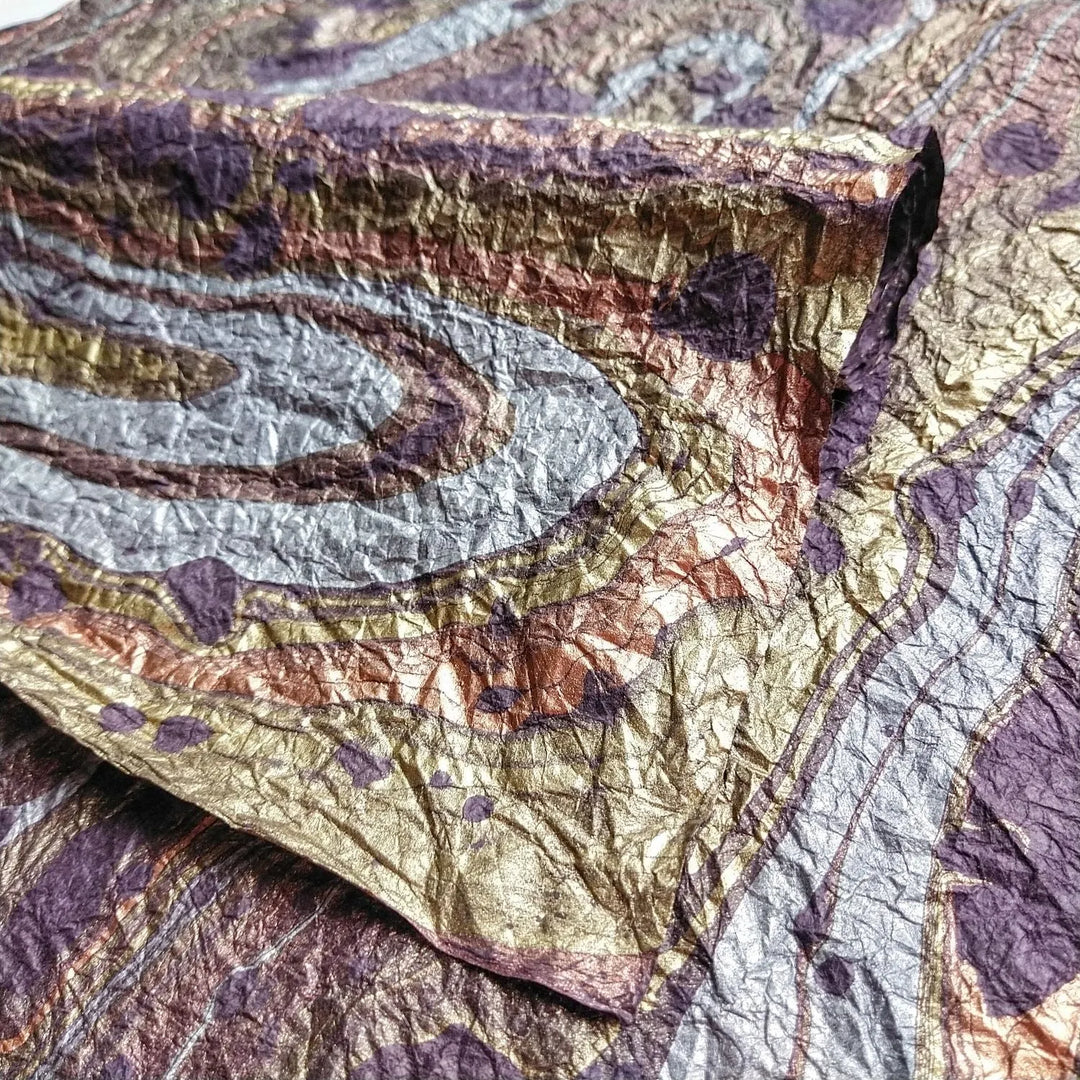 Close-up of Milano Kozo handmade mulberry paper, showing purple swirls and a unique handcrafted texture ideal for fine art and decor.
