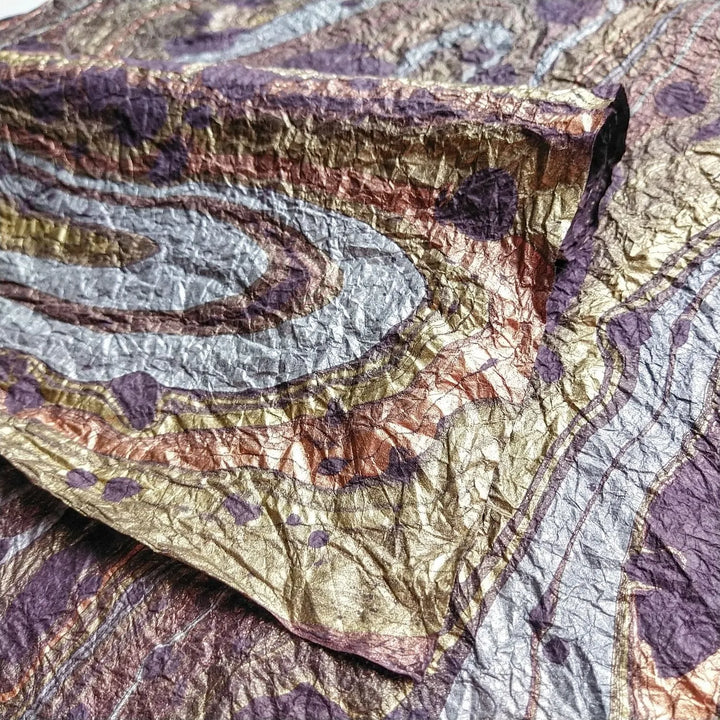 Close-up of Milano Kozo handmade mulberry paper, showing purple swirls and a unique handcrafted texture ideal for fine art and decor.