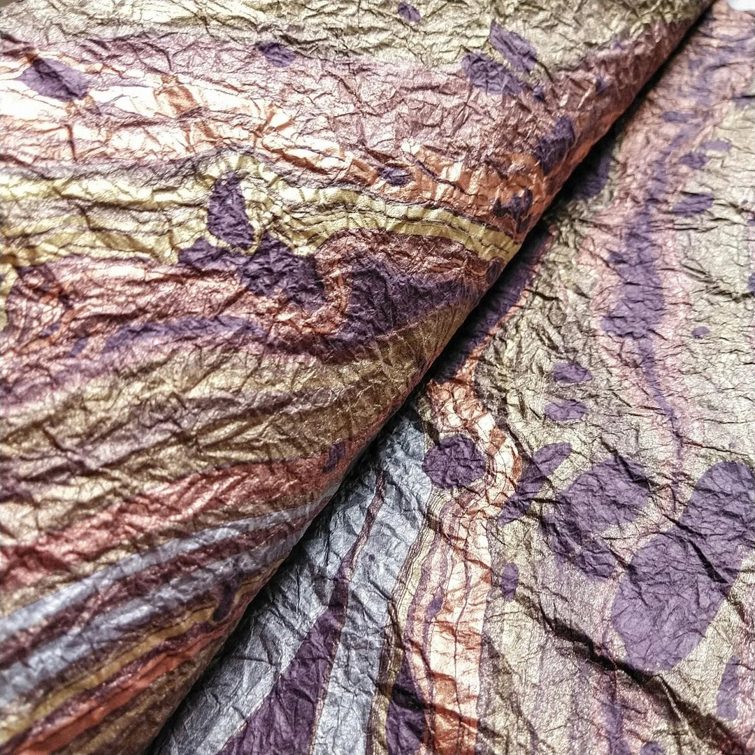 Artistic marbled mulberry paper in shades of purple, handcrafted at Kozo Studio with a signature texture and design perfect for creative projects.