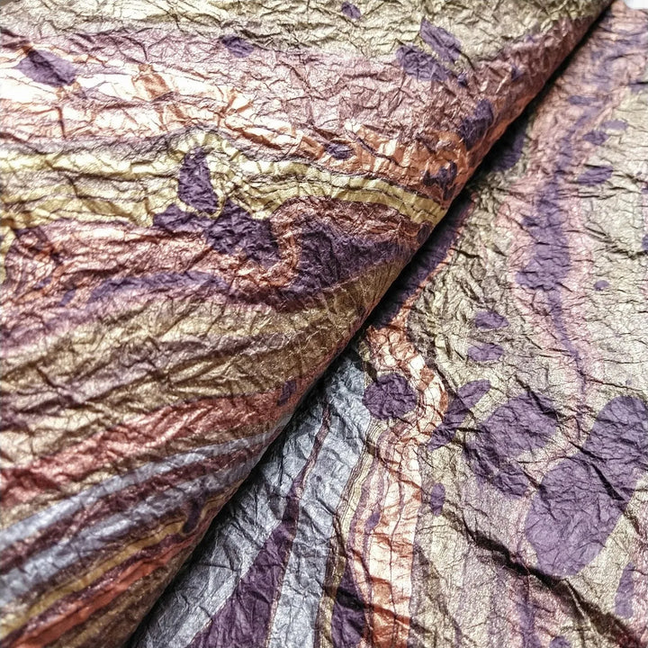 Artistic marbled mulberry paper in shades of purple, handcrafted at Kozo Studio with a signature texture and design perfect for creative projects.