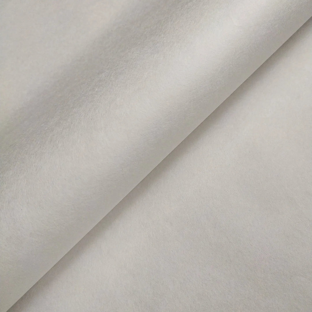 Close-up of two overlapping sheets of Kozo Studio Thin White Kozo Paper Roll (45 gsm), featuring a smooth, soft texture and light gray tone, forming a diagonal line where they meet.