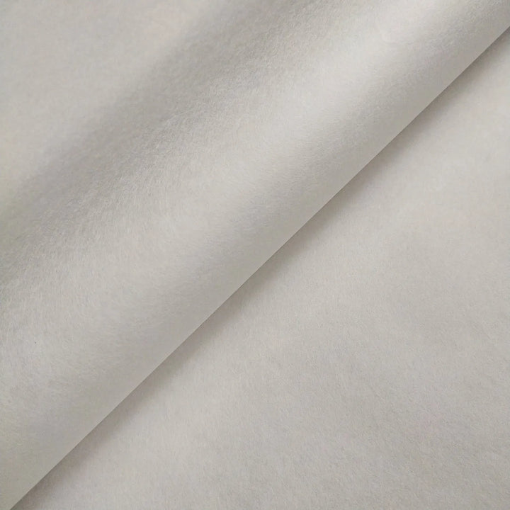 Close-up of two overlapping sheets of Kozo Studio Thin White Kozo Paper Roll (45 gsm), featuring a smooth, soft texture and light gray tone, forming a diagonal line where they meet.