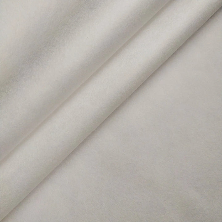Close-up of Kozo Studios Thin White Kozo Paper Roll (45 gsm) showing smooth, soft white paper with diagonal folds and fine texture, reminiscent of traditional washi printmaking. The material appears clean and evenly colored.
