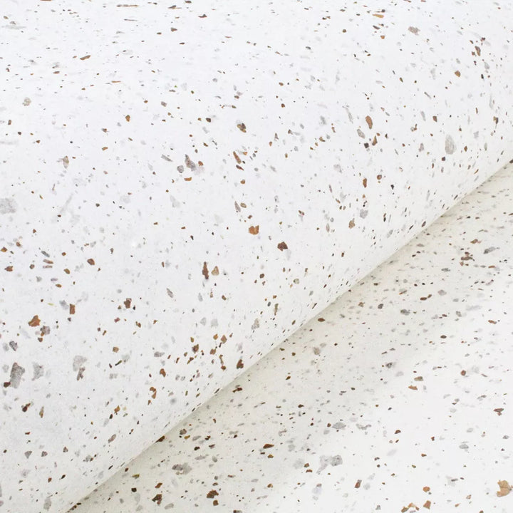 Rolled sheets of Tobac Confetti Kozo paper by Kozo Studio, blending the strength of mulberry paper with the texture of handmade paper and leaf-infused speckles.