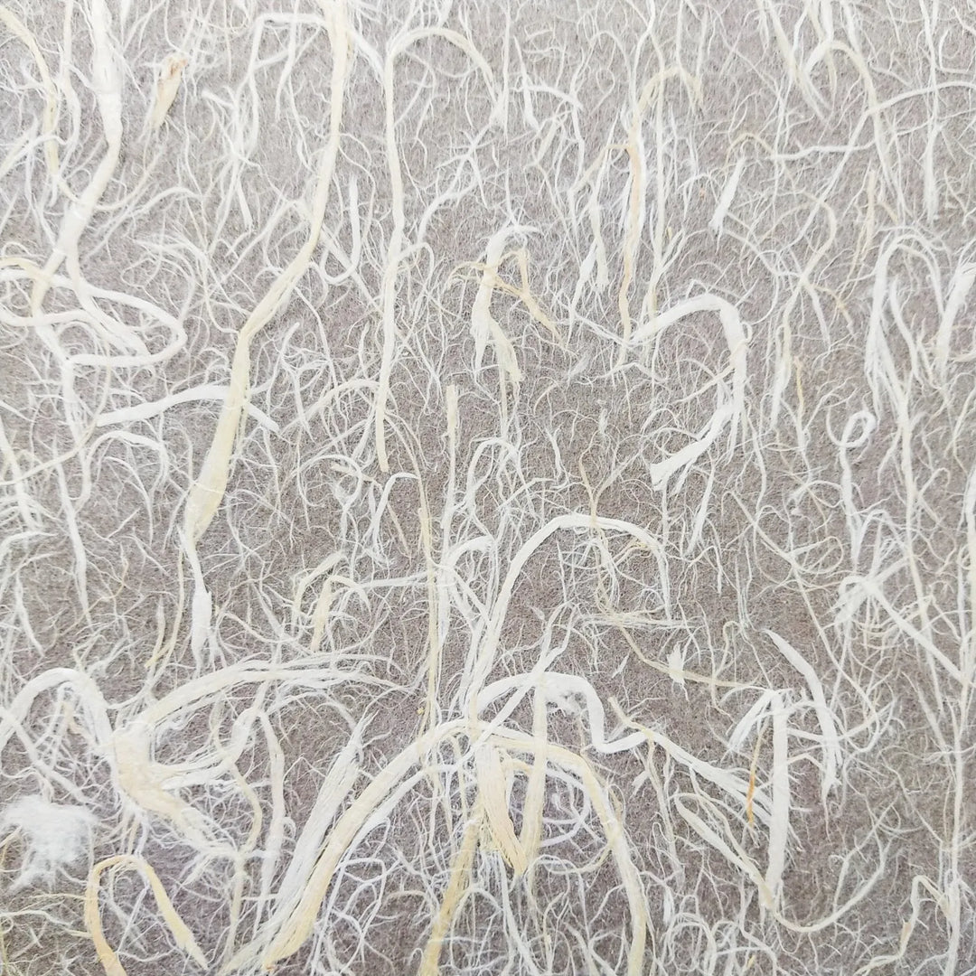 Close-up of Kozo Studios Full Mulberry Bark Unryu Paper, showcasing light-colored fibrous strands creating an abstract, organic pattern on a muted backdrop.