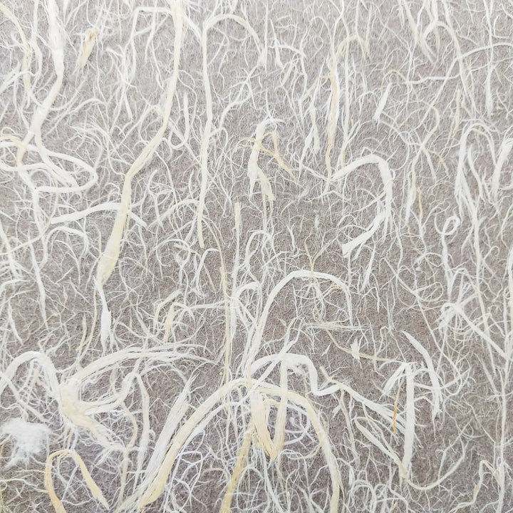 Close-up of Kozo Studios Full Mulberry Bark Unryu Paper, showcasing light-colored fibrous strands creating an abstract, organic pattern on a muted backdrop.