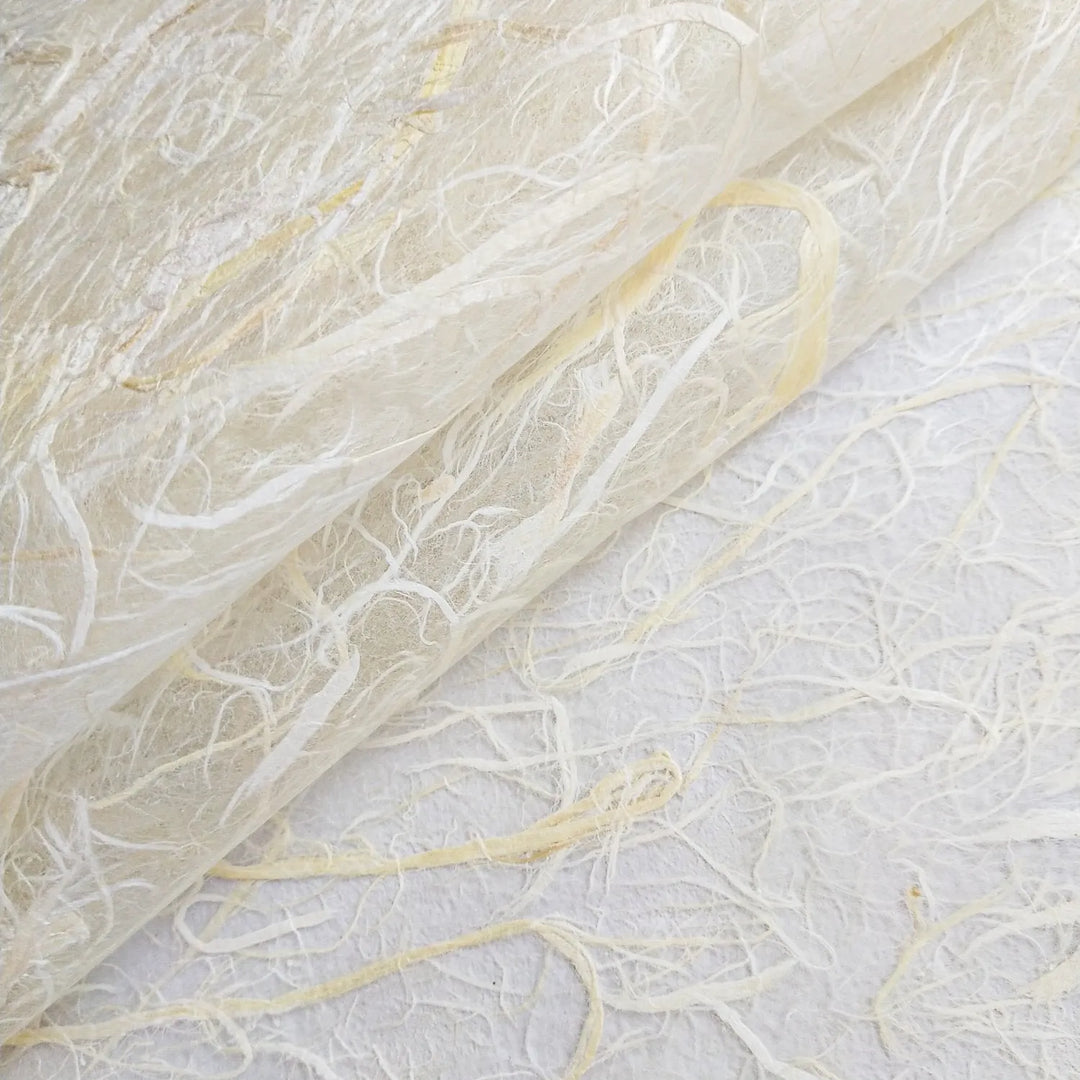 A close-up look at Kozo Studios Full Mulberry Bark Unryu Paper reveals its delicate, translucent texture with intertwined fibers in white and light cream, forming an organic pattern.