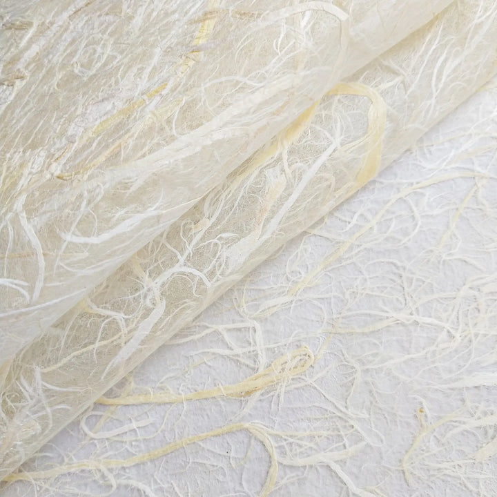 A close-up look at Kozo Studios Full Mulberry Bark Unryu Paper reveals its delicate, translucent texture with intertwined fibers in white and light cream, forming an organic pattern.