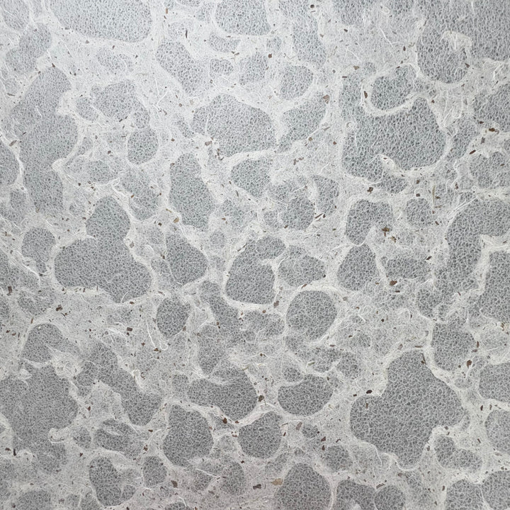 Tidal Lace Kozo Paper (Chiri) by Kozo Studio features a textured, handmade look with an irregular stone-like pattern in light gray, accented by darker gray lines and scattered small brown flecks.