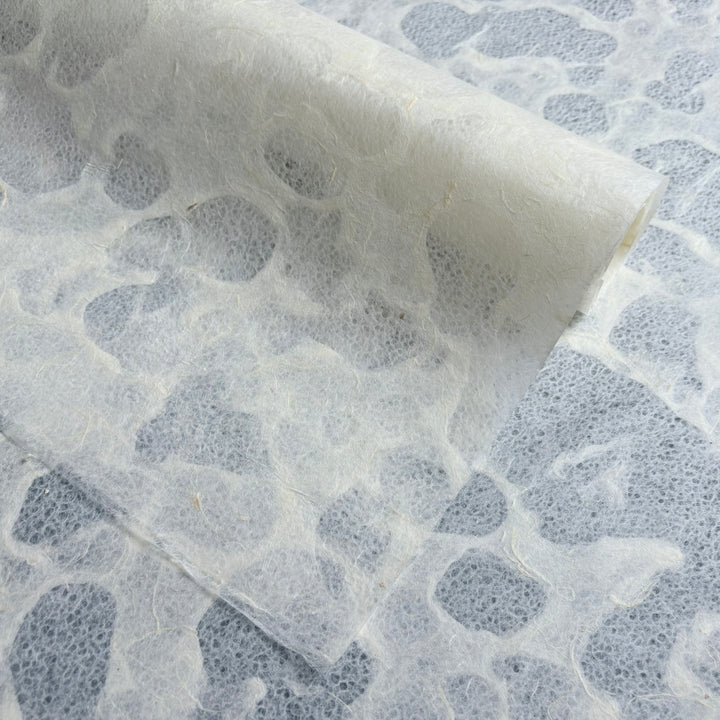 A close-up of Kozo Studios Tidal Lace Kozo Paper (Unryu) shows its semi-translucent, textured surface with an organic pattern and embedded fibers, highlighting the eco-conscious design and natural appeal.