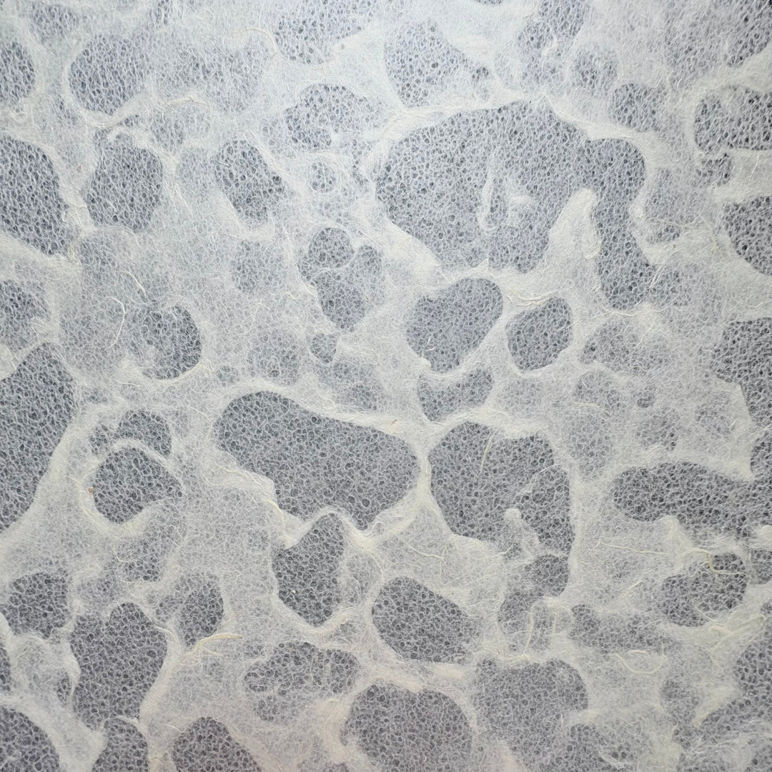 Tidal Lace Kozo Paper (Unryu) by Kozo Studio features a gray and white textured surface with irregular patches and wispy fibers, resembling abstract shapes and evoking the marbled look of eco-conscious handmade mulberry paper.
