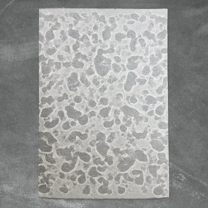 A rectangular white Tidal Lace Kozo Paper (Unryu) by Kozo Studio, featuring an organic, marbled pattern, is displayed on a textured gray surface.