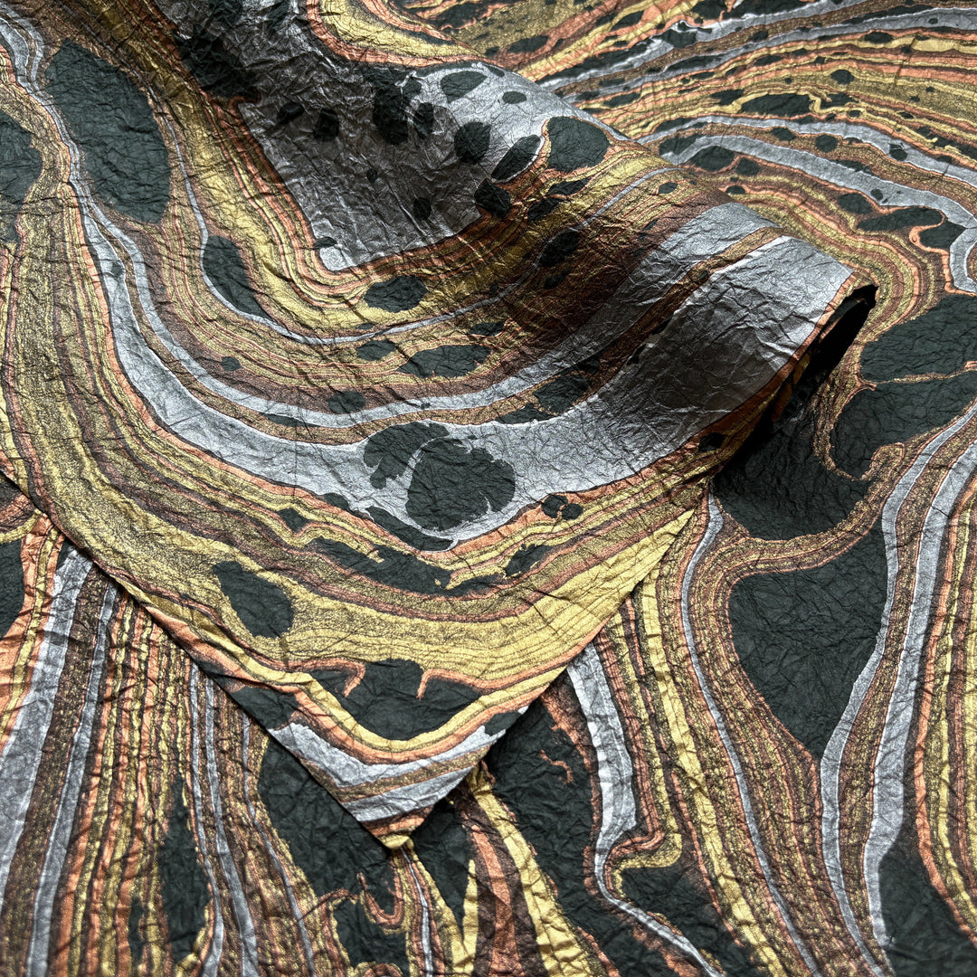 Milano Kozo Paper – Design 9 (Green) embodies artisanal beauty with its graceful marbled design. Handmade by delicately layering mulberry paper over swirling oil-based colors, each sheet boasts a distinct, one-of-a-kind pattern and a soft, fabric-like crinkled texture. Its sophisticated look and exceptional quality make it ideal for creative projects, detailed crafts, or as a striking decorative statement on its own.
