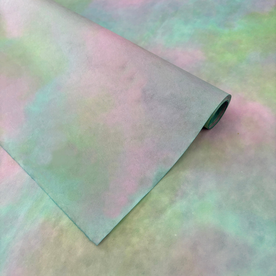 Abstract mulberry paper sheet in muted pink and green earthy pastel tones.