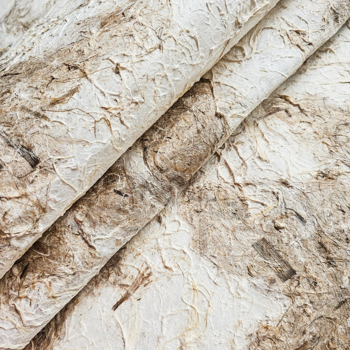 Close-up of textured mulberry paper from Kozo Studio, showcasing a handmade paper with a rough surface and earthy two-tone colors perfect for art and decor projects.