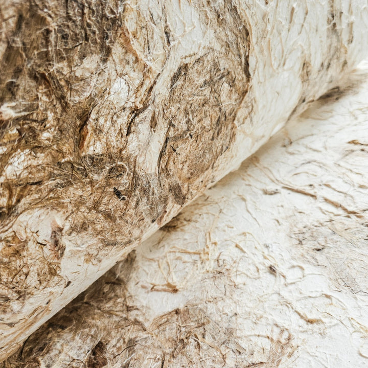 Handmade mulberry paper sheet from Kozo Studio with a raw, tactile finish and warm earth tones, designed for versatile art and home decor projects.