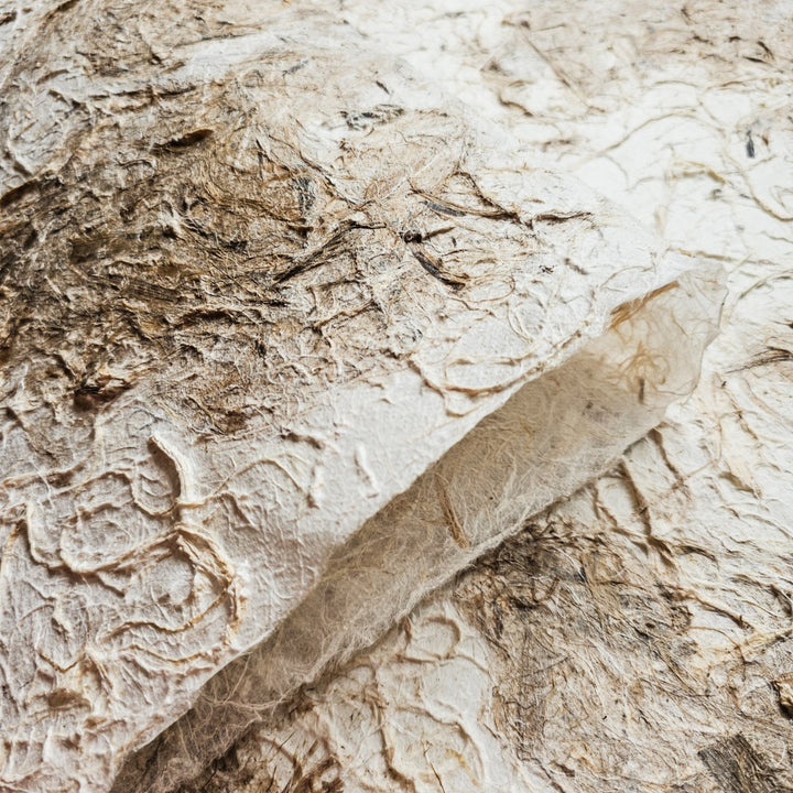 Detailed image of Kozo Studio's handmade mulberry paper, highlighting its unique two-tone color and rough texture perfect for craft, collage, or interior design.