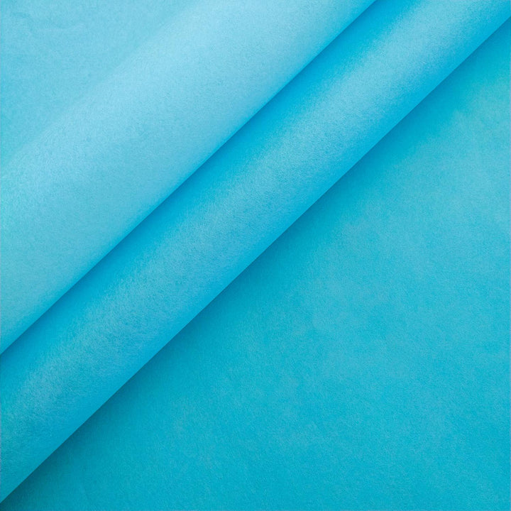
Close-up of three stacked sheets of Kozo Studio handmade paper in Atoll Blue, showcasing the soft texture and curled edges of premium mulberry paper against a light blue background.