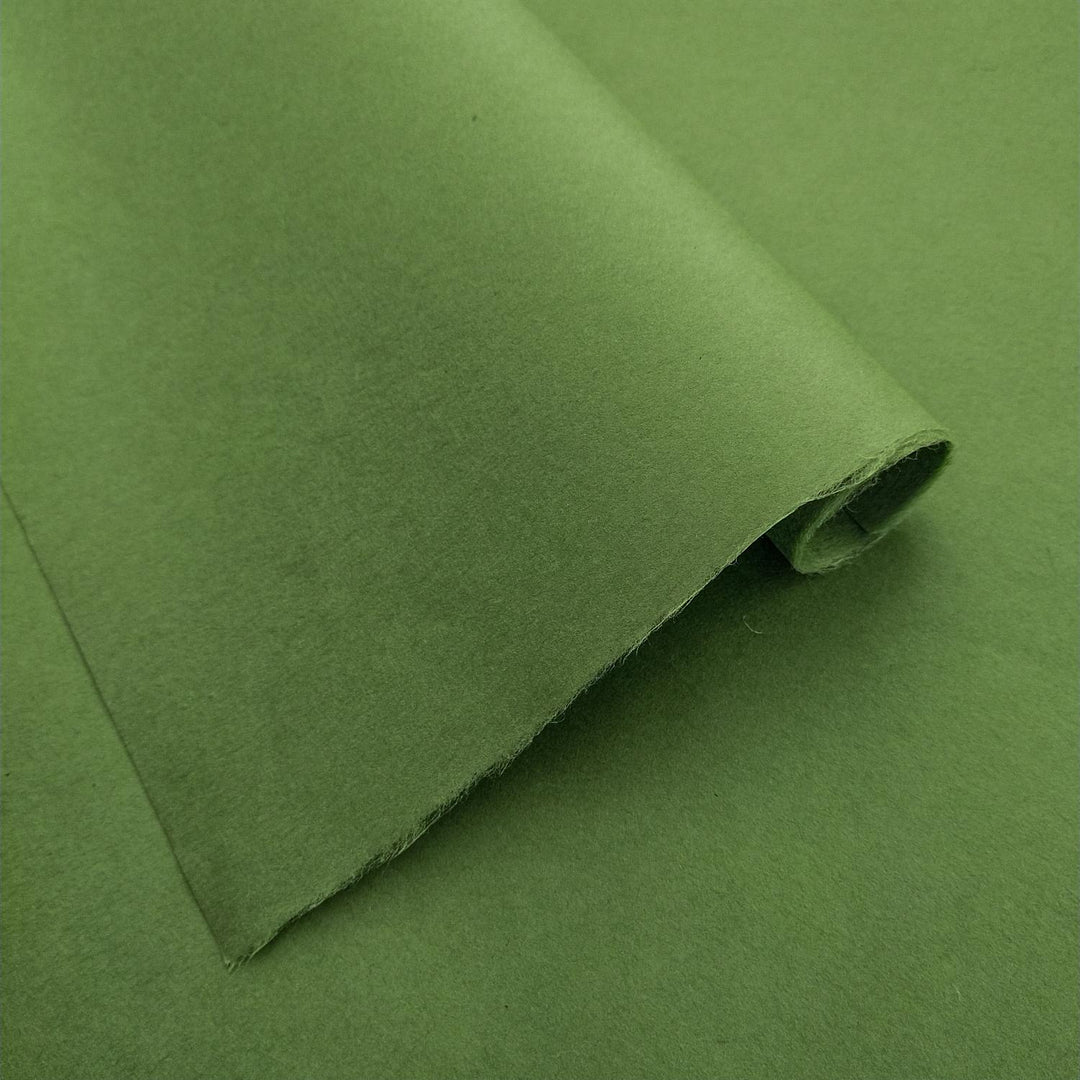 Fern green mulberry paper by Kozo Studio in a detailed view, highlighting the even tone and smooth handmade paper surface with natural folds and light play.