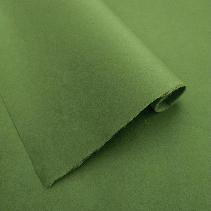 Fern green mulberry paper by Kozo Studio in a detailed view, highlighting the even tone and smooth handmade paper surface with natural folds and light play.