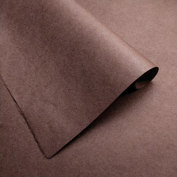 Handmade paper in tawny brown from Kozo Studio showing delicate creases and rich, even color tones.