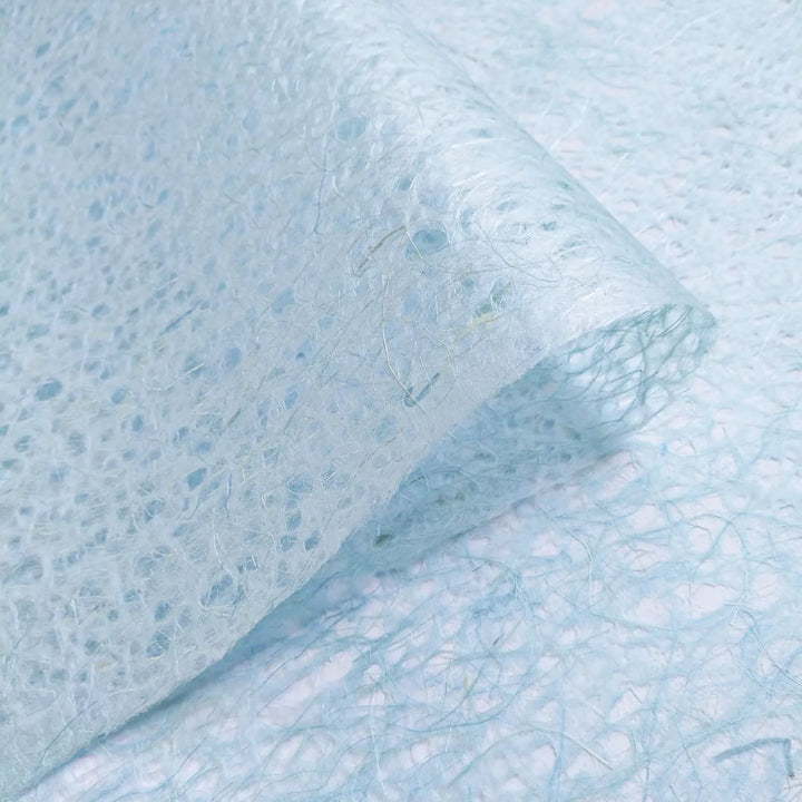 Light blue Kozo Studio handmade paper close-up, highlighting translucent mulberry paper quality and fine web-like fiber patterns.
